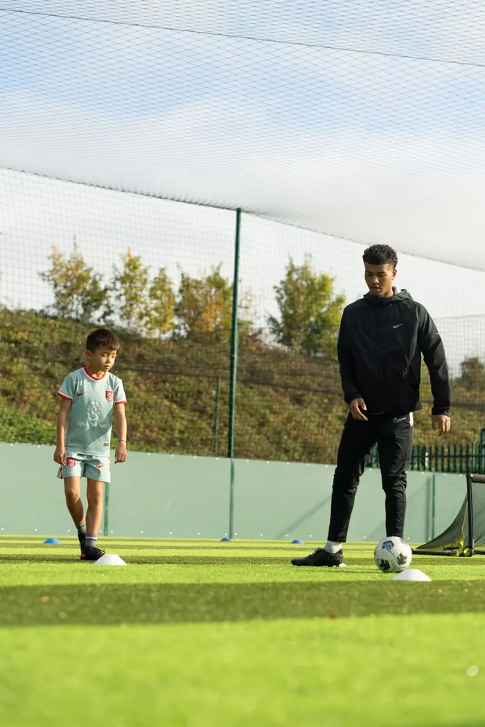 The coach working one to one with a young player