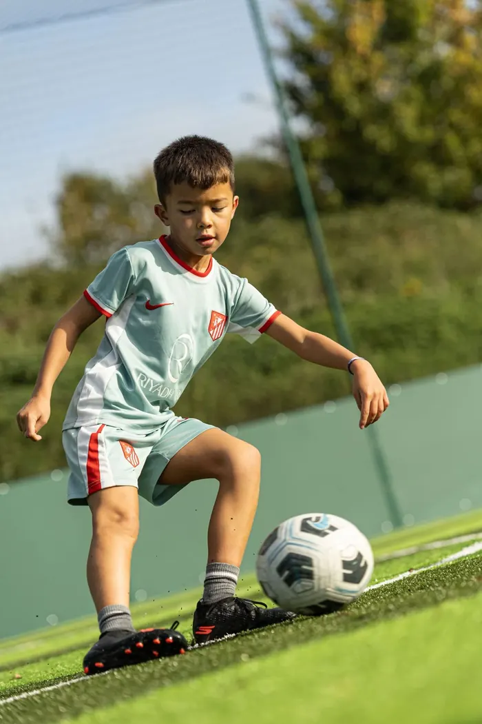 A young player concentrating as he controls the ball